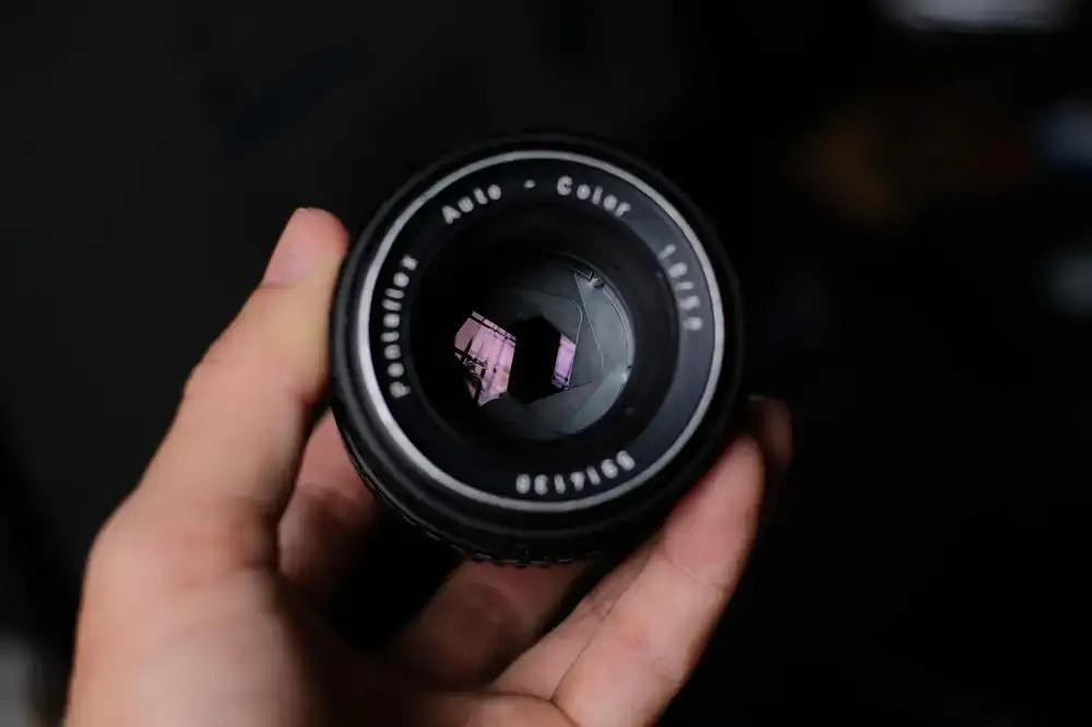 Technician carefully adjusting the internal optics of a vintage lens